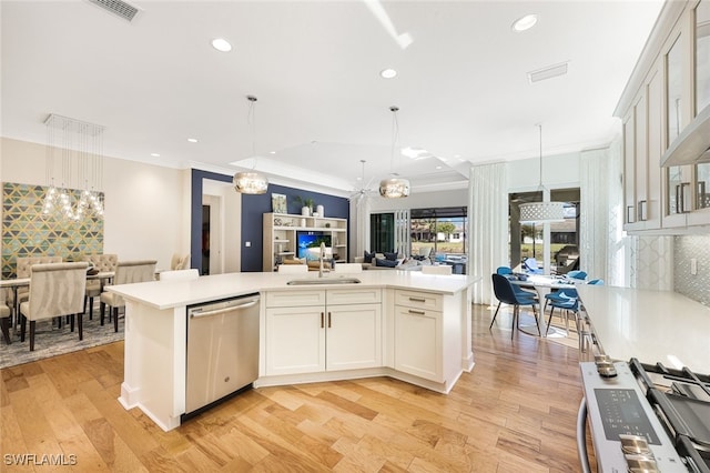 kitchen featuring tasteful backsplash, an island with sink, white cabinetry, hanging light fixtures, and stainless steel appliances