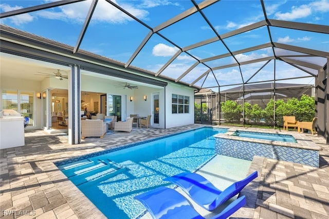 view of pool featuring a lanai, ceiling fan, a patio area, an outdoor hangout area, and an in ground hot tub