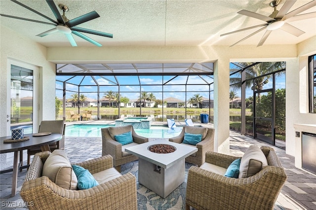 view of patio with a lanai, an outdoor living space with a fire pit, and ceiling fan