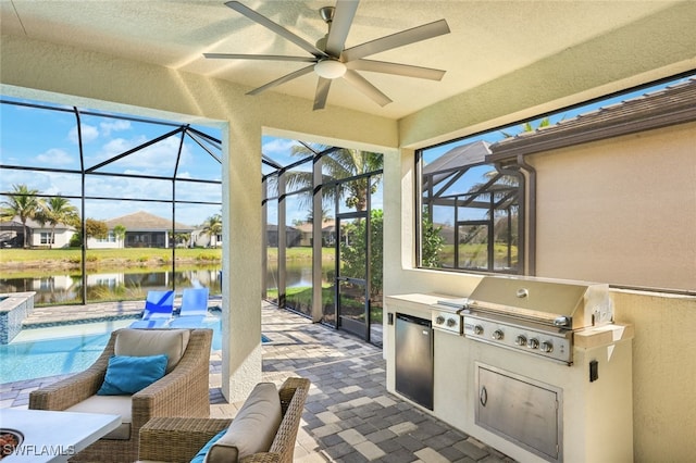 view of patio / terrace with area for grilling, a lanai, a water view, and exterior kitchen