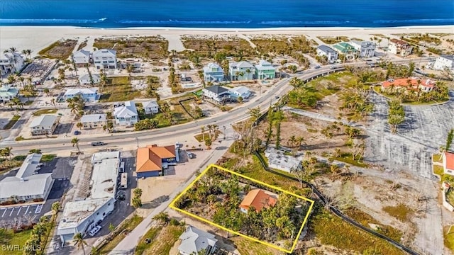 birds eye view of property with a water view and a beach view