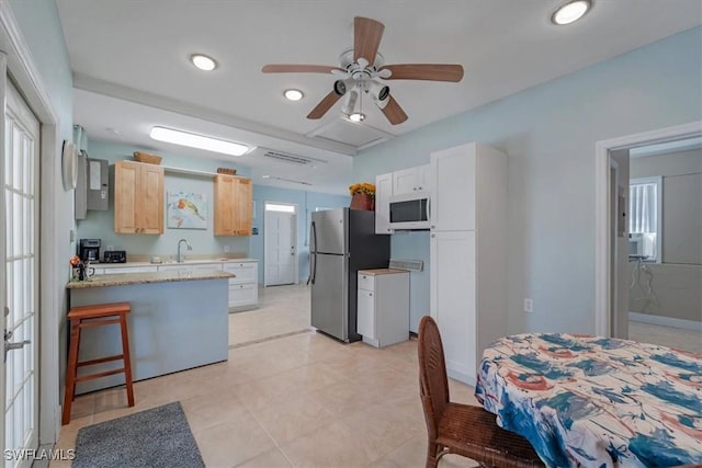 kitchen featuring white cabinetry, light brown cabinets, stainless steel refrigerator, and cooling unit