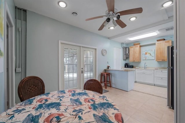 bedroom with a ceiling fan, freestanding refrigerator, french doors, and a sink