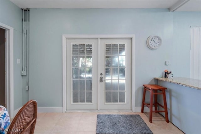 doorway to outside featuring light tile patterned floors, baseboards, and french doors