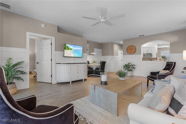 living room with ceiling fan and light wood-type flooring