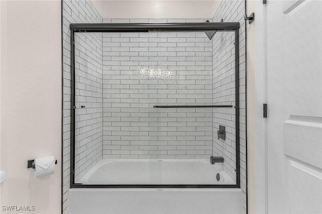 bathroom with combined bath / shower with glass door