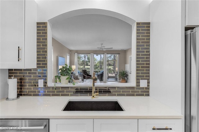 kitchen featuring white cabinetry, sink, stainless steel dishwasher, and decorative backsplash