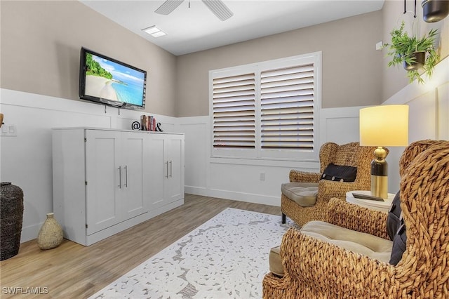 living area with ceiling fan and light hardwood / wood-style flooring