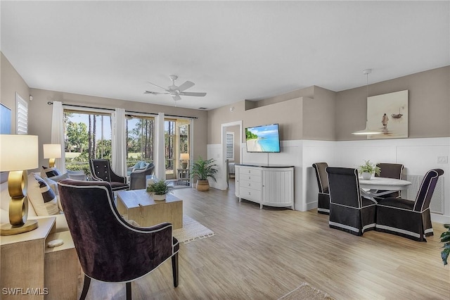 living room with ceiling fan and light hardwood / wood-style flooring