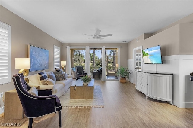 living room with light hardwood / wood-style flooring and ceiling fan