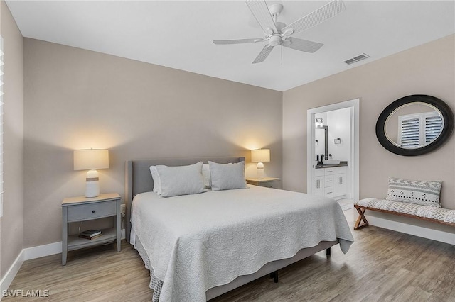 bedroom with ceiling fan, wood-type flooring, and connected bathroom