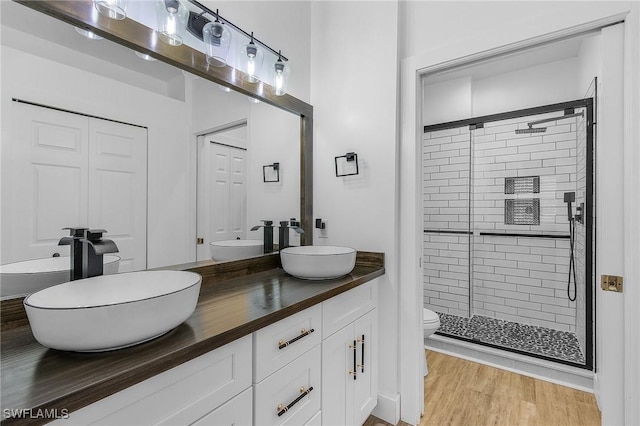 bathroom with vanity, hardwood / wood-style floors, an enclosed shower, and toilet