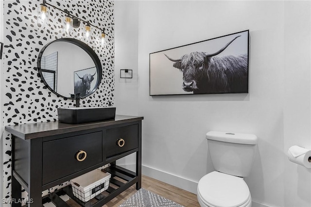 bathroom featuring wood-type flooring, toilet, and vanity