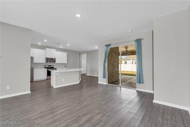 unfurnished living room featuring sink and hardwood / wood-style floors