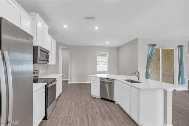 kitchen featuring white cabinetry, an island with sink, stainless steel appliances, and sink