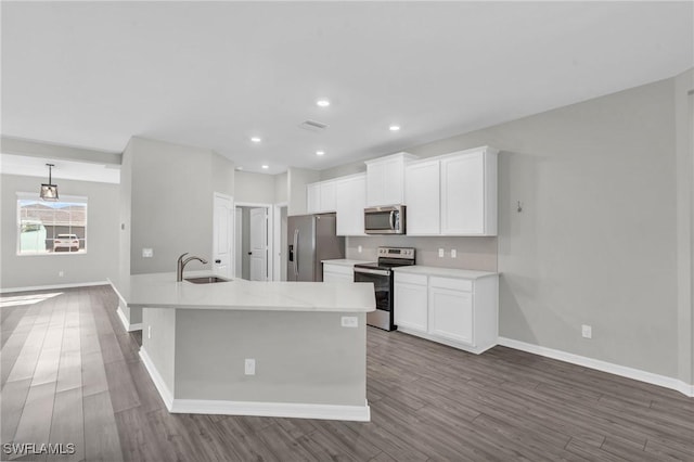 kitchen featuring appliances with stainless steel finishes, wood-type flooring, and white cabinets