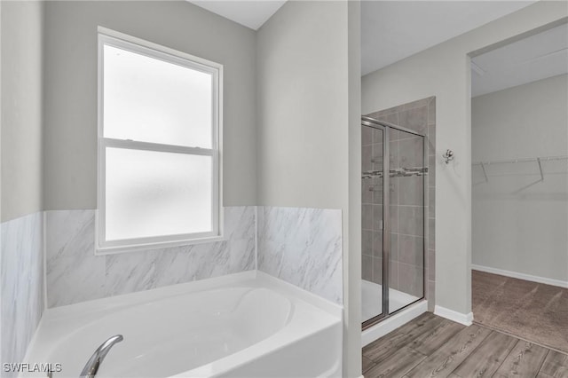 bathroom with hardwood / wood-style flooring and separate shower and tub