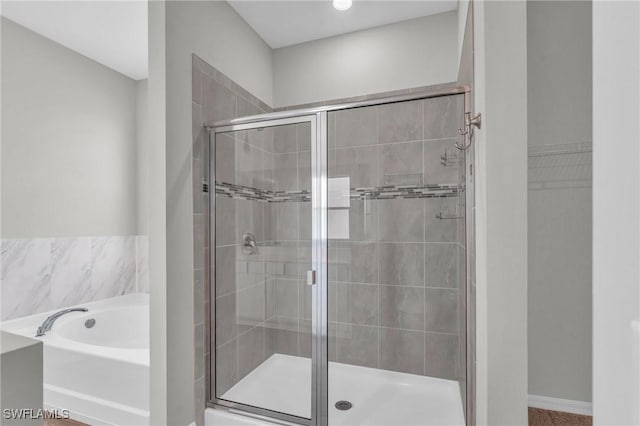 bathroom featuring separate shower and tub