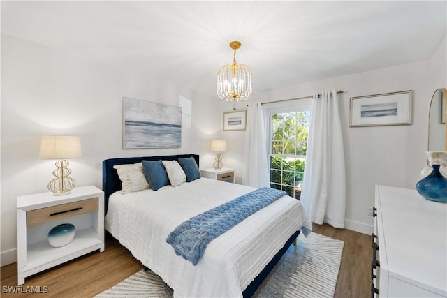 bedroom with hardwood / wood-style flooring and a notable chandelier