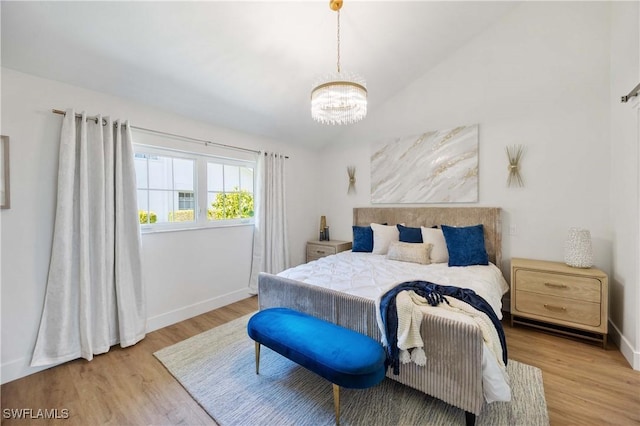 bedroom featuring lofted ceiling, an inviting chandelier, and light wood-type flooring