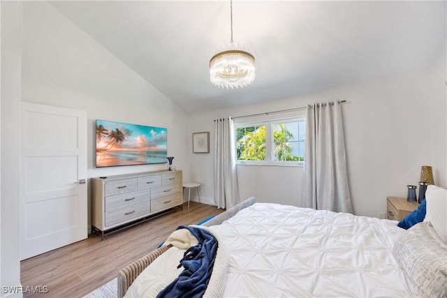 bedroom featuring lofted ceiling, a notable chandelier, and light hardwood / wood-style flooring