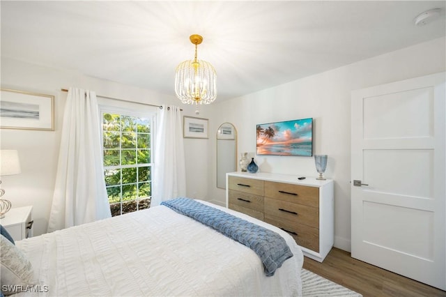 bedroom featuring dark wood-type flooring and a notable chandelier