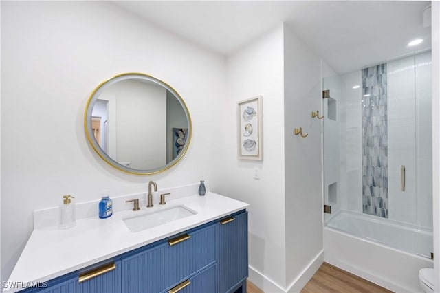 full bathroom with vanity, wood-type flooring, toilet, and washtub / shower combination