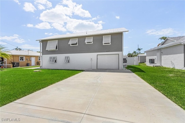 rear view of house with a garage and a lawn