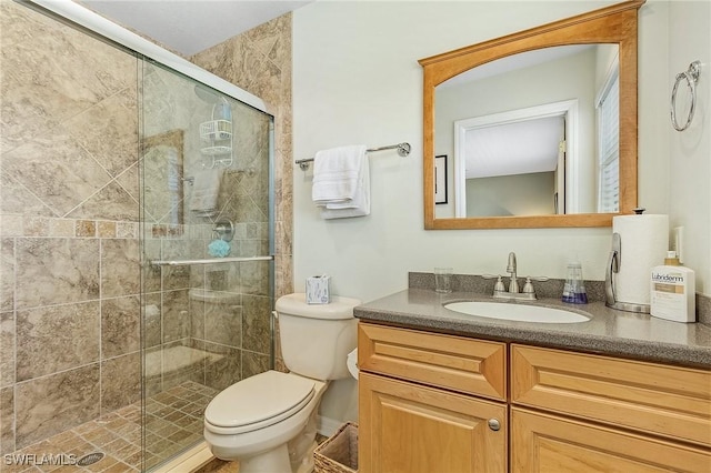 bathroom with vanity, an enclosed shower, and toilet