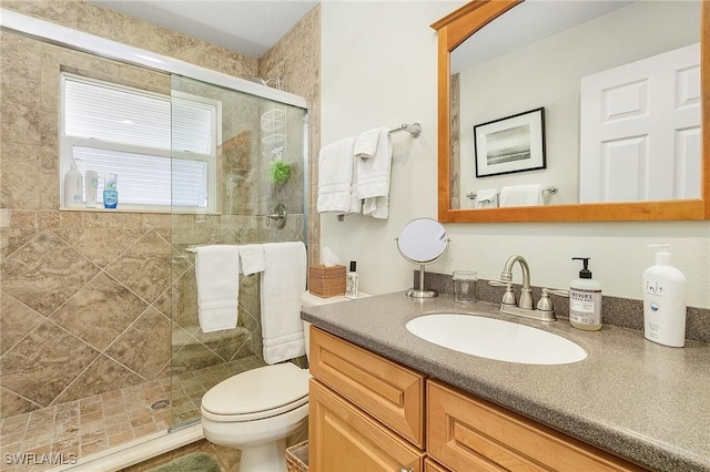 bathroom featuring walk in shower, vanity, and toilet