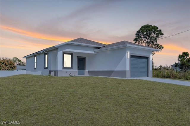 view of front of house featuring a garage and a lawn