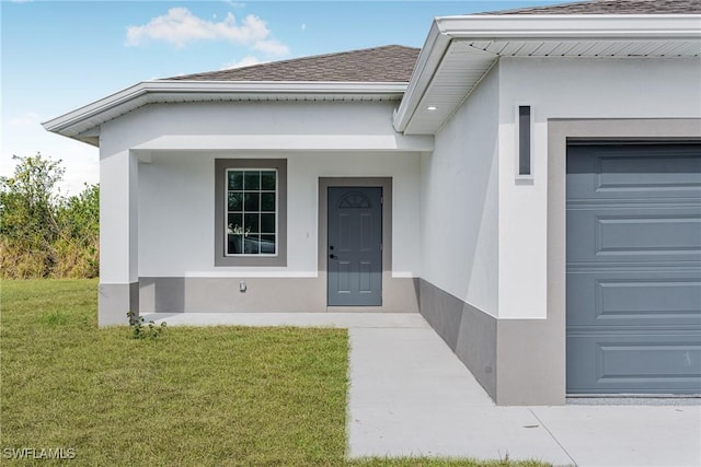 doorway to property featuring a garage and a yard