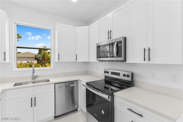 kitchen featuring white cabinetry, sink, light stone counters, and stainless steel appliances