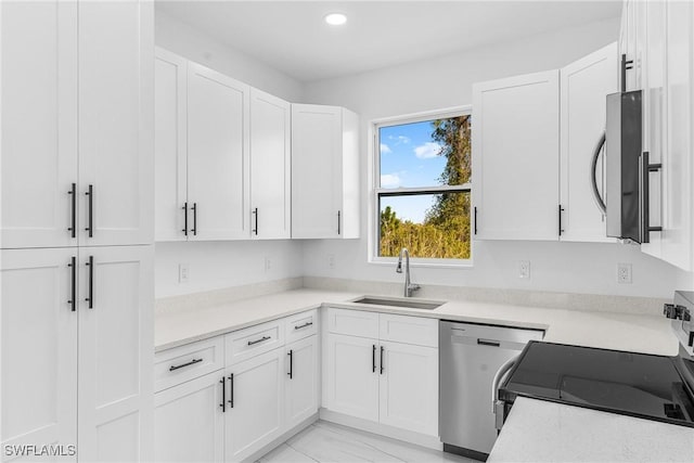 kitchen with stainless steel appliances, white cabinetry, and sink