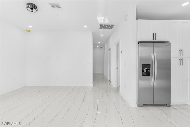 kitchen with white cabinetry and stainless steel fridge