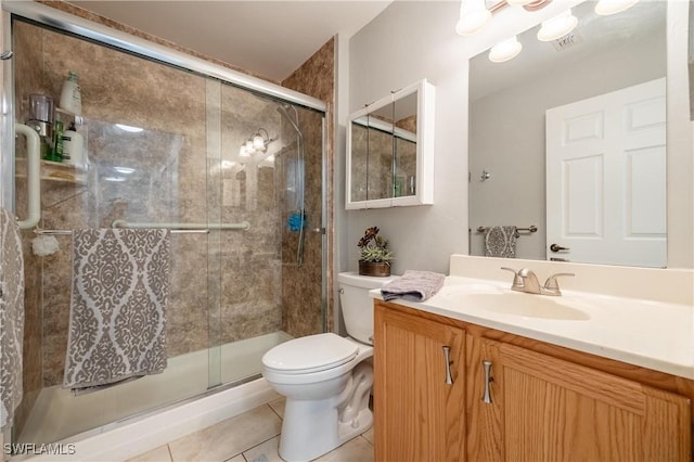 bathroom with tile patterned flooring, vanity, a shower with door, and toilet