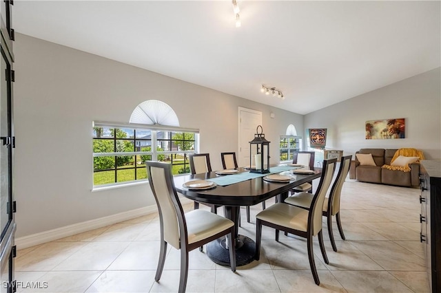 dining area featuring lofted ceiling, light tile patterned floors, and a wealth of natural light