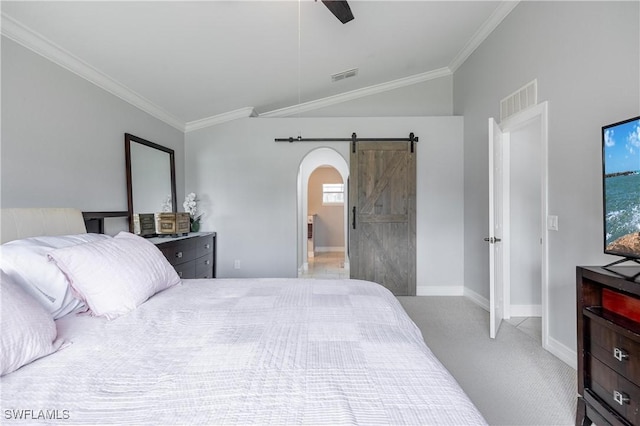 carpeted bedroom with a barn door, ornamental molding, lofted ceiling, and ceiling fan