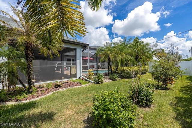 view of yard with a fenced in pool and glass enclosure