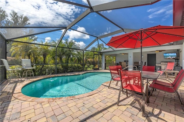 view of swimming pool featuring ceiling fan, a patio, and glass enclosure