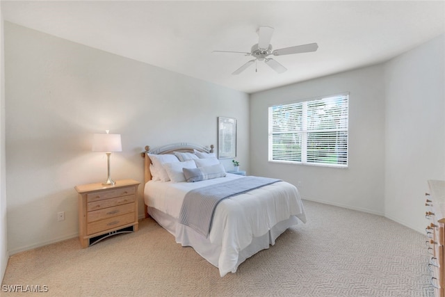 bedroom with ceiling fan and light carpet