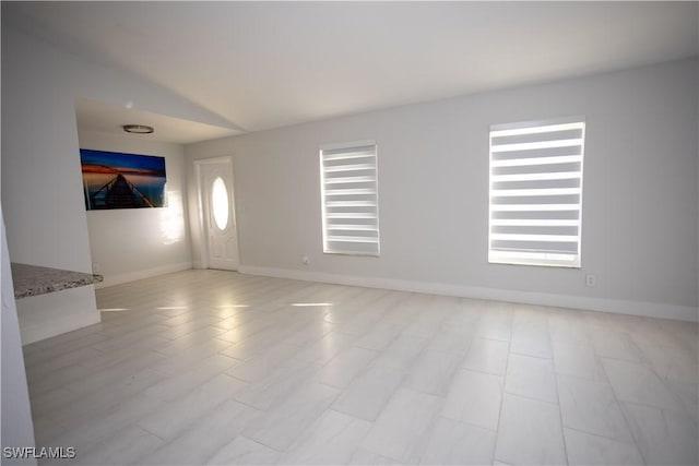 spare room with lofted ceiling