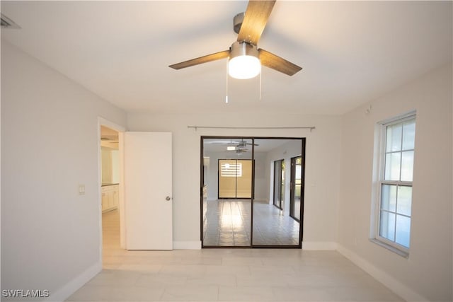 empty room with a wealth of natural light and ceiling fan