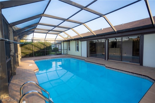 view of pool with a patio and glass enclosure