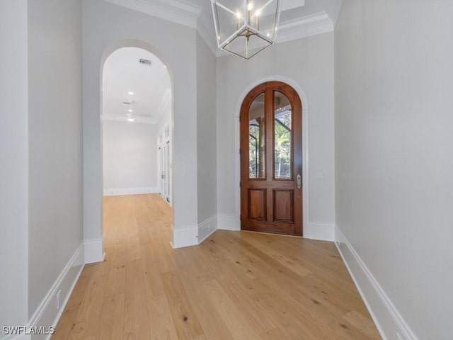 entrance foyer with ornamental molding and light hardwood / wood-style flooring