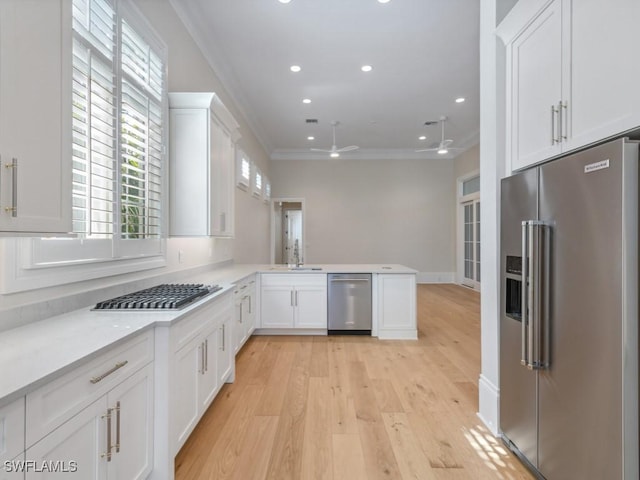 kitchen featuring sink, white cabinetry, light hardwood / wood-style flooring, appliances with stainless steel finishes, and kitchen peninsula