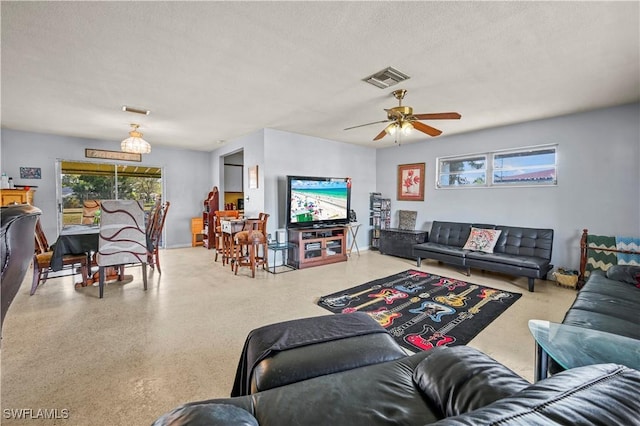 living room featuring ceiling fan and a textured ceiling