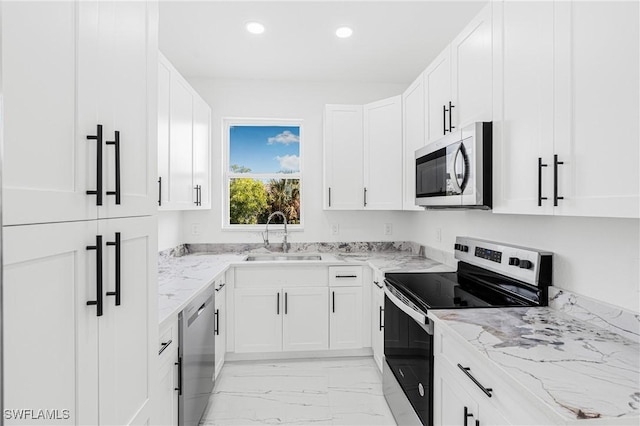 kitchen with white cabinetry, sink, light stone countertops, and appliances with stainless steel finishes