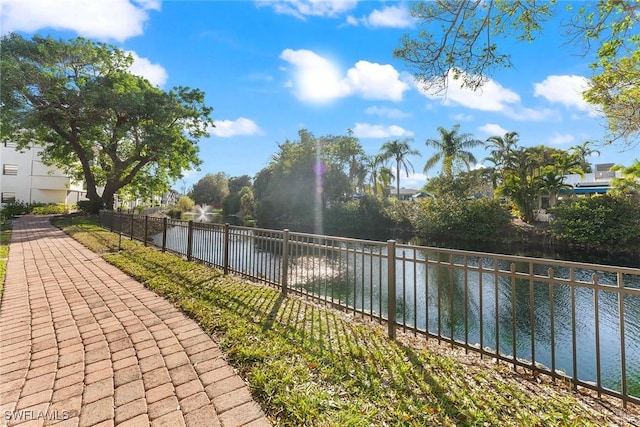 view of property's community featuring a water view and fence