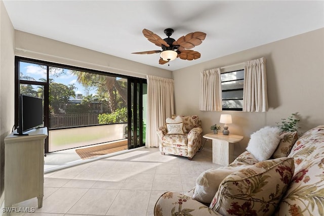 living area with light tile patterned floors and a ceiling fan